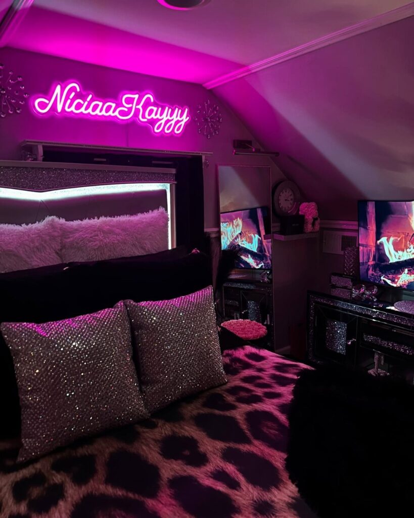 Leopard print blanket and sparkly pillows in a bedroom with pink neon lighting.