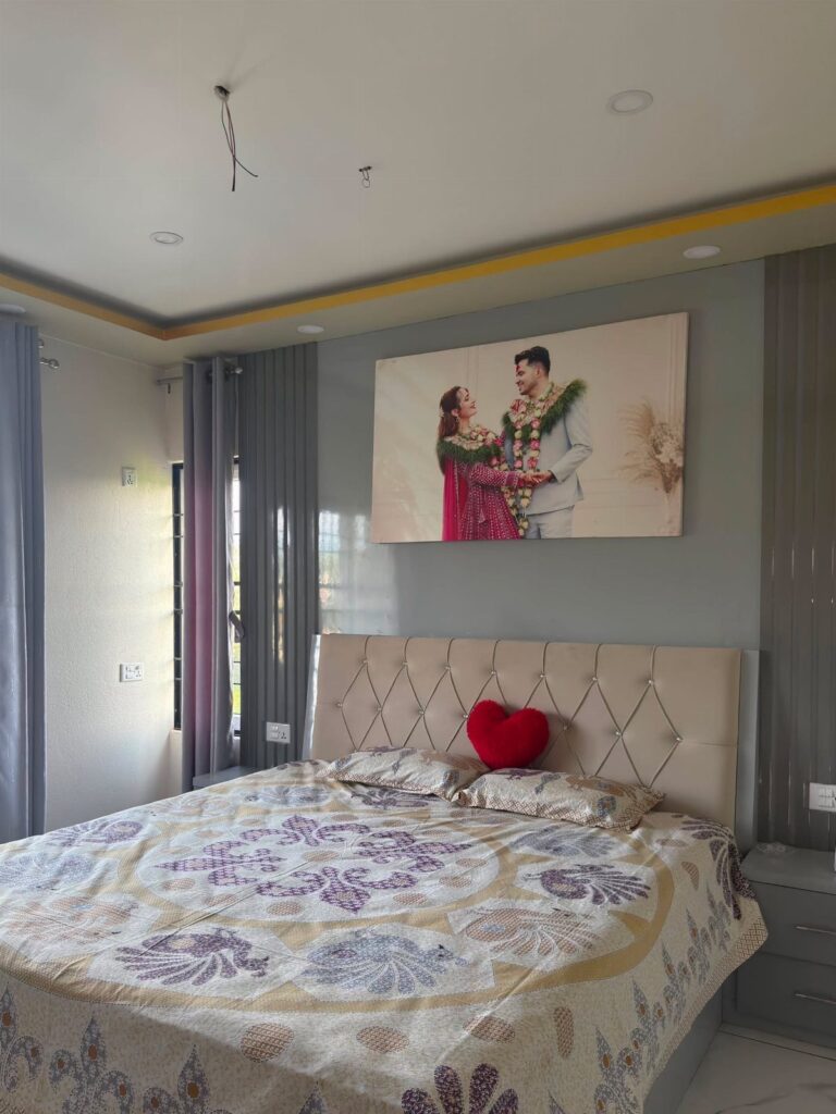 Bed with heart pillow and a large canvas wedding photo on the wall