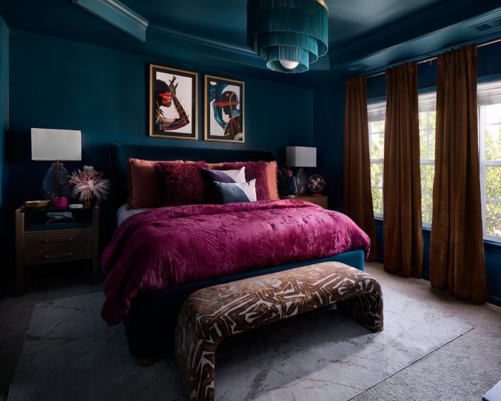 Deep teal bedroom walls with a magenta velvet bed and brown curtains.