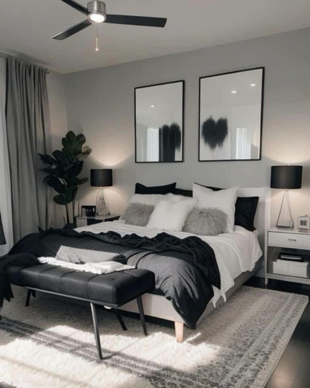 Modern bedroom with grey walls, black and white bedding, and abstract wall art.