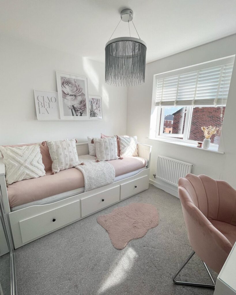 White daybed with pink bedding and patterned pillows in a bright modern bedroom.